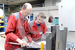 Apprentice and trainer in a metalworking company - apprenticeship in the trade photo