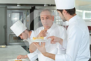 Apprentices chefs at work with experienced master photo