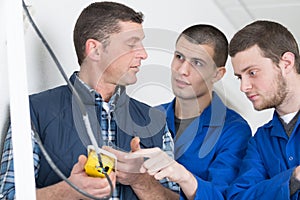 Apprentices learning to use machine