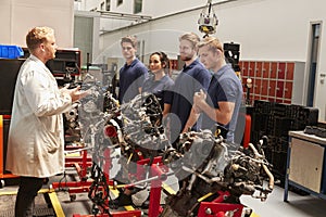 Apprentices studying car engines with a mechanic photo