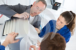 Apprentices and technician inspecting aircondition