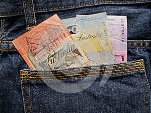 approach to back pocket of jeans in blue with Australian banknotes