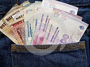 approach to front pocket of jeans in blue with argentinean banknotes photo