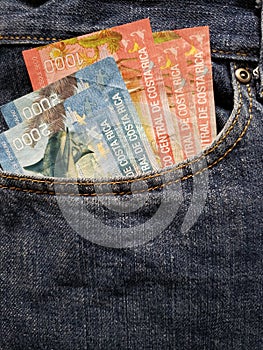 approach to front pocket of jeans in blue with Costa Rican banknotes