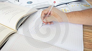 Approach to a human hand writing: BANKS, ACCOUNTS RECEIVABLE, ACCOUNTS PAYABLE in a list of expenses in a ledger on wooden table photo