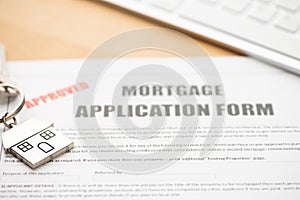 Approved mortgage loan agreement application with house shaped keyring