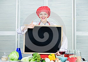 Approving something. Cute woman gesturing thumbs up with blank blackboard. Chief cook teaching in cooking school. Master