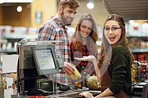 ?appy cashier woman on workspace in supermarket shop