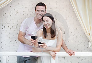 Ð appy couple enjoying a glasses of red wine indoors
