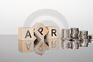 APR - the text is made up of letters on wooden cubes lying on a mirror surface