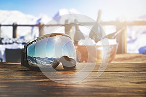 Apres ski - goggles with mountains reflection on the restaurant table at ski resort