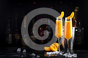 Apricot Bellini alcoholic cocktail drink with prosecco, cava, or sparkling wine with apricot puree, syrup and ice, dark bar