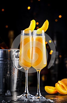 Apricot Bellini alcoholic cocktail drink with prosecco, cava, or sparkling wine with apricot puree, syrup and ice, dark bar