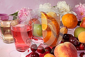 Apricot and cherry juice, apricots, cherries and grapes on a sunny table