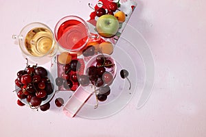 Apricot and cherry juice, apricots, cherries and grapes on a sunny table, top view, selective focus