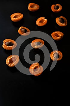 apricot halves with pits on a dark background