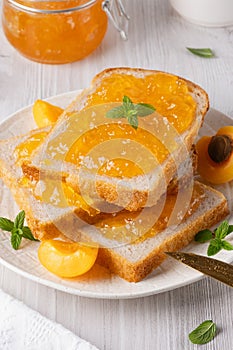 Apricot jam on bread in a white plate