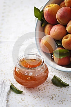 Apricot jam with fresh apricots in the background