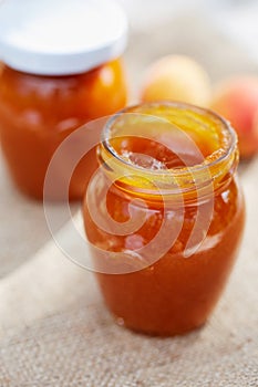 Apricot jam in glass jars with fresh fruit