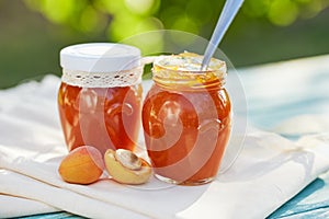 Apricot jam in glass jars with fresh fruit