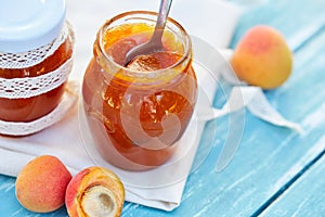 Apricot jam in glass jars on table