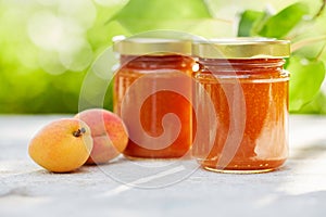 Apricot jam in glass jars on a wooden table