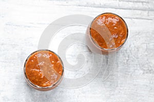 Apricot jam in two glass jars on the table.