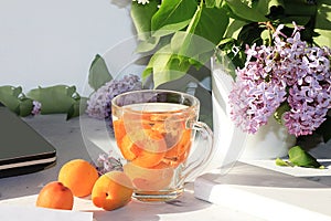 Apricot juice and apricots on a sunny table.