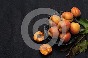 Apricots in a bowl on black background
