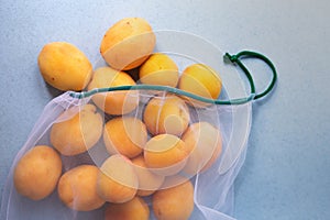 Apricots in eco-friendly packaging. Reusable bags for vegetables and fruits. Shopping in the store. Eco-friendly packaging. Caring