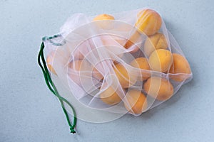 Apricots in eco-friendly packaging. Reusable bags for vegetables and fruits. Shopping in the store, retail. Eco-friendly packaging