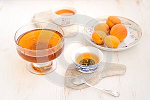 Apricots, honey and tea on a white background