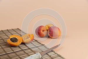 Apricots and knife on a peachy background