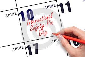 April 10. Hand writing text International Safety Pin Day on calendar date. Save the date.