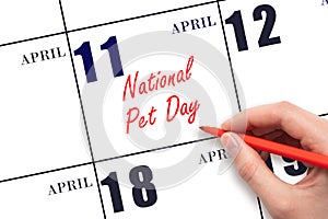 April 11. Hand writing text National Pet Day on calendar date. Save the date.