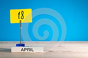 April 18th. Day 18 of april month, calendar on little yellow tag. Spring time. Empty space for text, mockup or template
