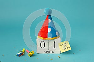 April 1st. Image of april 1 wooden calendar and festive decor on the blue background. April Fool's Day