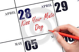 April 28. Hand writing text Kiss Your Mate Day on calendar date. Save the date.