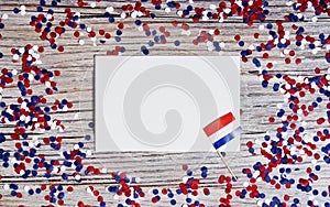 April 30 . mini flags with paper confetti and sheets of white paper. The concept of Netherlands independence Day and national day