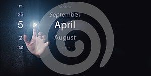 April 5th. Day 5 of month, Calendar date. Hand click luminous icon PLAY and DATE on dark blue background. Spring month, day of the
