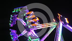 April 6, 2024 - Kehl, Germany: Illuminated spinning pendulum ride at night. Amusement park for family and friends. Parts