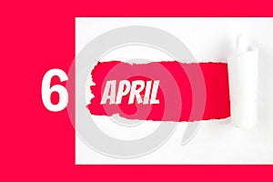 April 6th. Day 6 of month, Calendar date. Red Hole in the white paper with torn sides with calendar date. Spring month, day of the