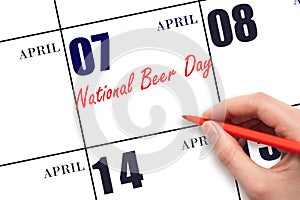 April 7. Hand writing text National Beer Day on calendar date. Save the date.