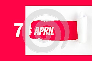 April 7th. Day 7 of month, Calendar date. Red Hole in the white paper with torn sides with calendar date. Spring month, day of the