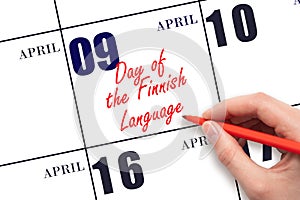 April 9. Hand writing text Day of the Finnish Language on calendar date. Save the date.