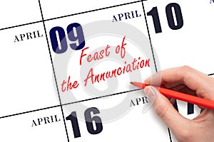 April 9. Hand writing text Feast of the Annunciation on calendar date. Save the date.