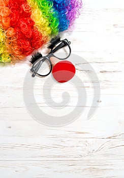 April Fool\'s Day clowning props. Clown costume accessories on white wooden background