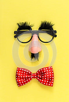 April Fool\'s Day clowning props. Clown costume accessories on yellow background