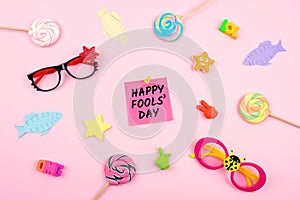 April Fools ' Day celebration background with paper fish, sticky note and decor on pink background. All Fools ' Day, humor, prank,