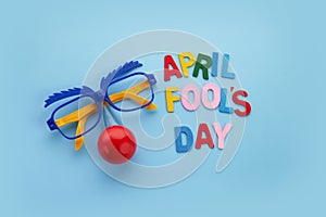 April Fools Day text and funny glasses on blue background